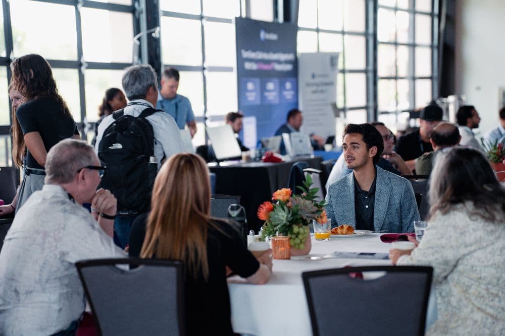 Breakfast crowd at round tables in the pavilion