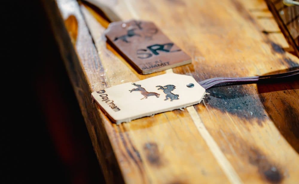 Leather luggage tags branded with the AI Summit and Daydream marks