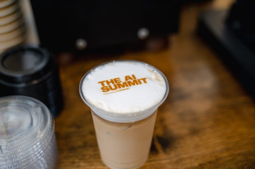 Iced latte with The AI Summit logo printed on the foam