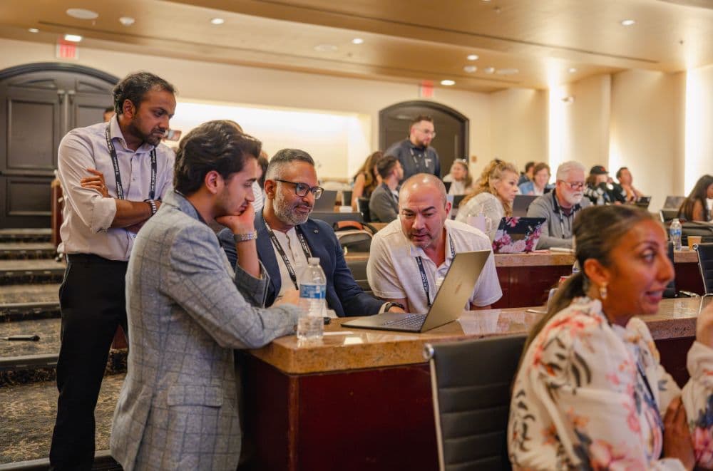 Attendees gathered around a laptop during a Let's Build session