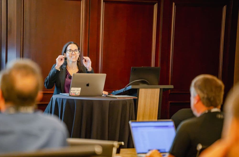 Speaker gesturing during a lightning talk with the audience in the foreground